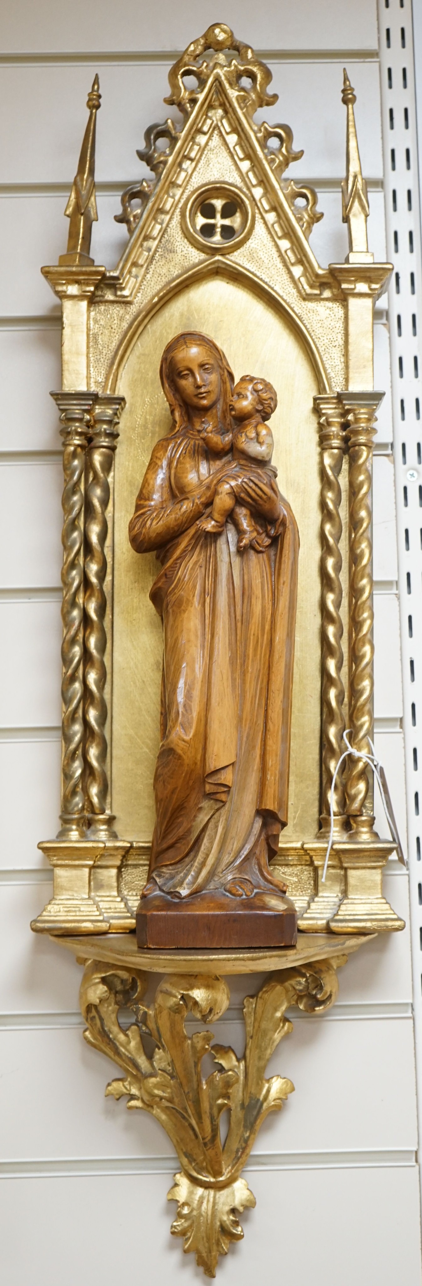 A 19th century architectural gilt niche and a 20th century carved pine group of Madonna and child 88cm